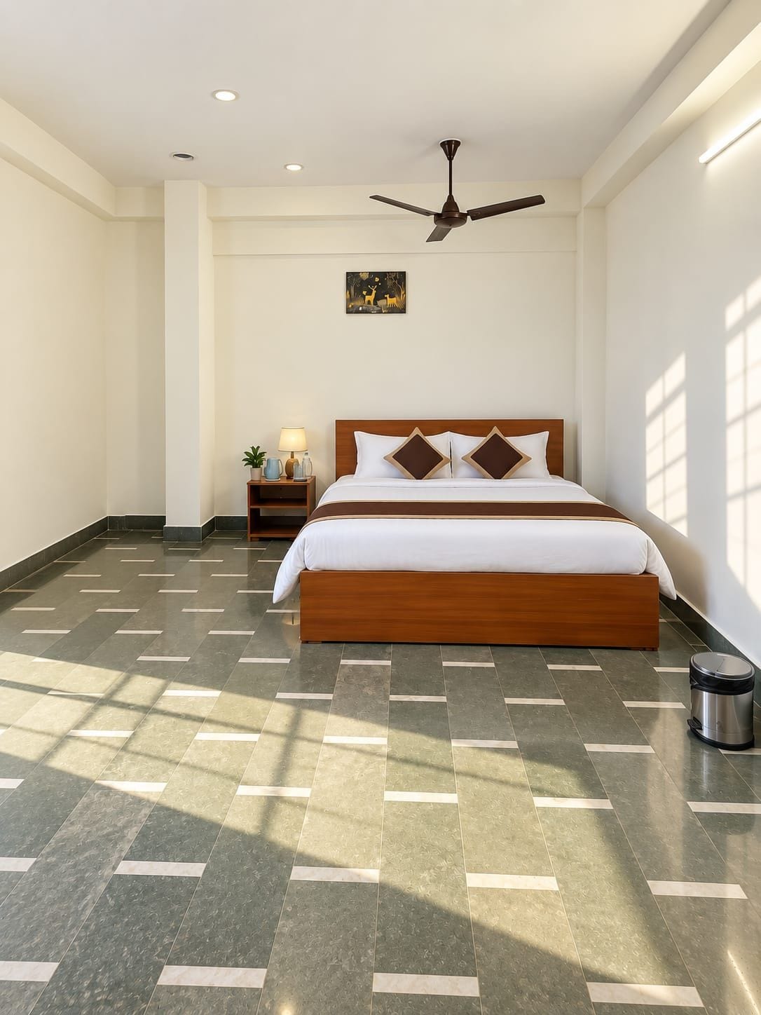 A hotel room with a large bed, a ceiling fan, a nightstand with a lamp, and a picture on the wall.