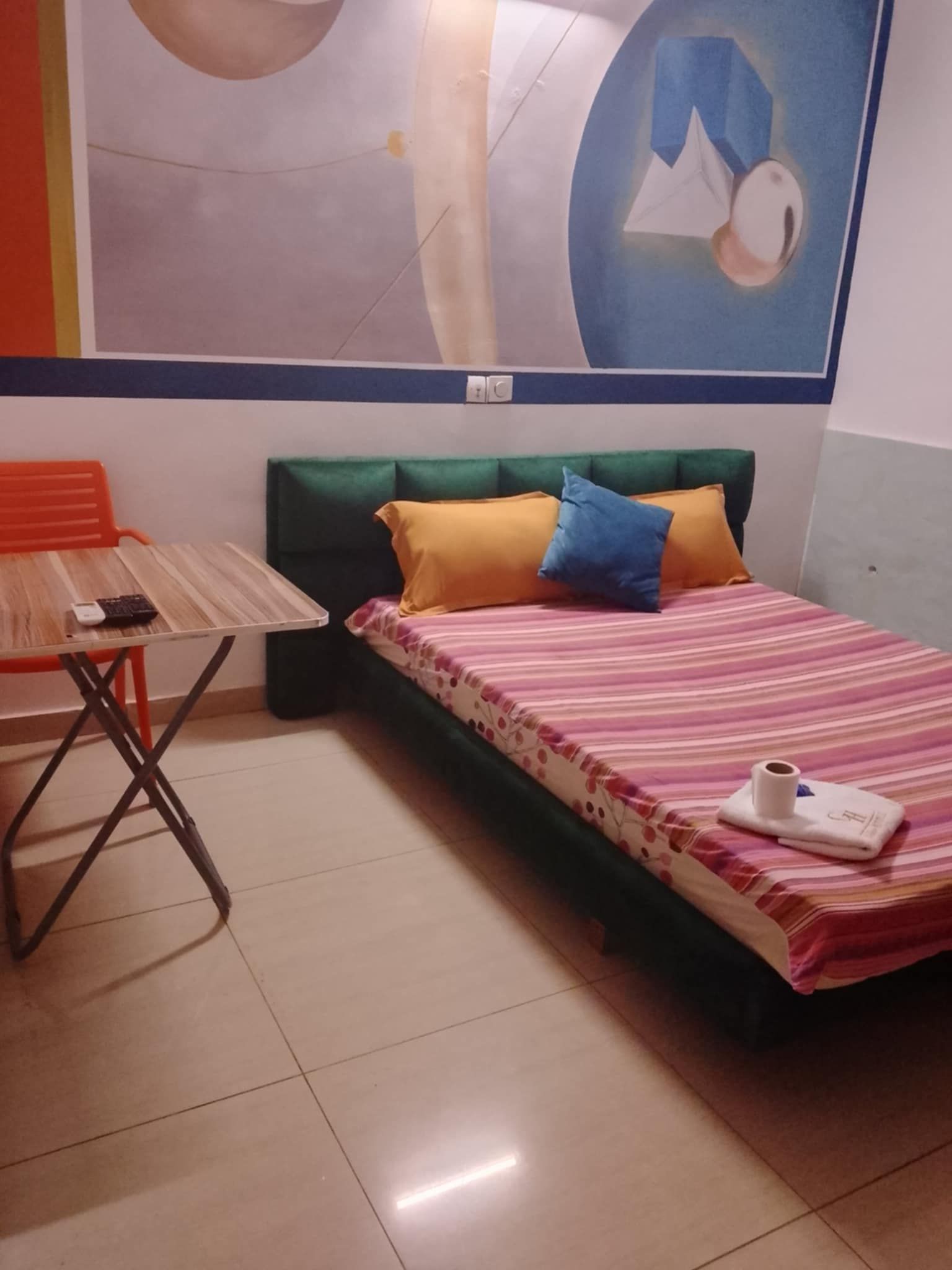 Una habitación con una cama, una mesa y una silla.