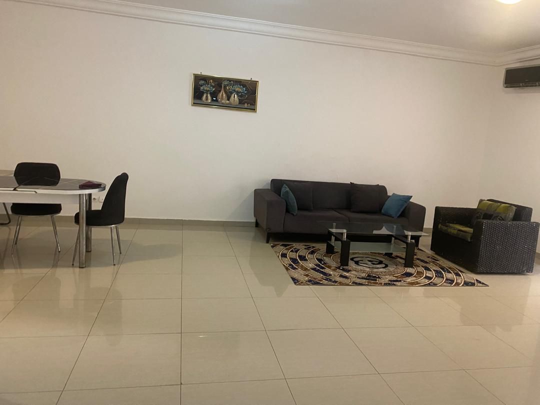 Una sala de estar con sofá, una mesa de centro y un comedor con sillas.