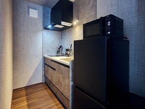 A compact kitchen with a built-in microwave, a refrigerator, and a sink. - HOTEL SOVA Kumamoto Ekimae (Kumamotoshi)