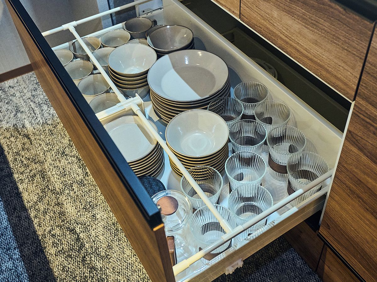 Un cajón con platos y vasos ordenados, que muestra una solución de almacenamiento bien organizada.