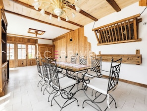 Ein Essbereich mit Holztisch und -stühlen, einer Chandelier und Holzwänden.