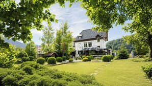 Une maison à deux étages, dotée d’une pelouse bien entretenue et agrémentée de divers arbustes.