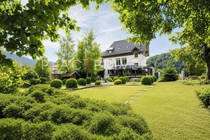 Ein zweistöckiges Haus mit gepflegtem Rasen und verschiedenen Sträuchern.