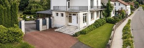 A modern two-story house with a front entrance, a driveway, and a well-maintained lawn. - Wonderful 2-bedroom house in Saint-Maurice-sur-Moselle awaits you (Saint-Maurice-sur-Moselle)
