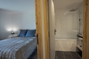 A bedroom with a bed, a nightstand, and a lamp.