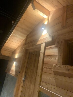 A wooden ceiling with exposed beams and recessed lighting.