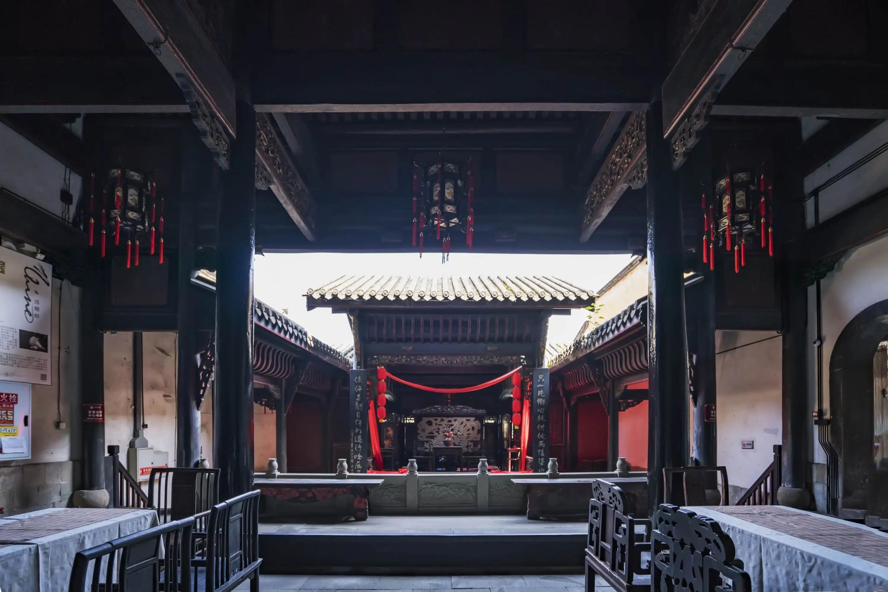 Une structure architecturale chinoise traditionnelle, caractérisée par une cour intérieure, des lanternes rouges et un toit recouvert de tuiles.