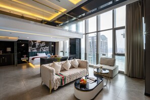 A modern living room with a sofa, a coffee table, and a view of the cityscape through large windows. - Chongqing Ashan River View Hotel (Chongqing)