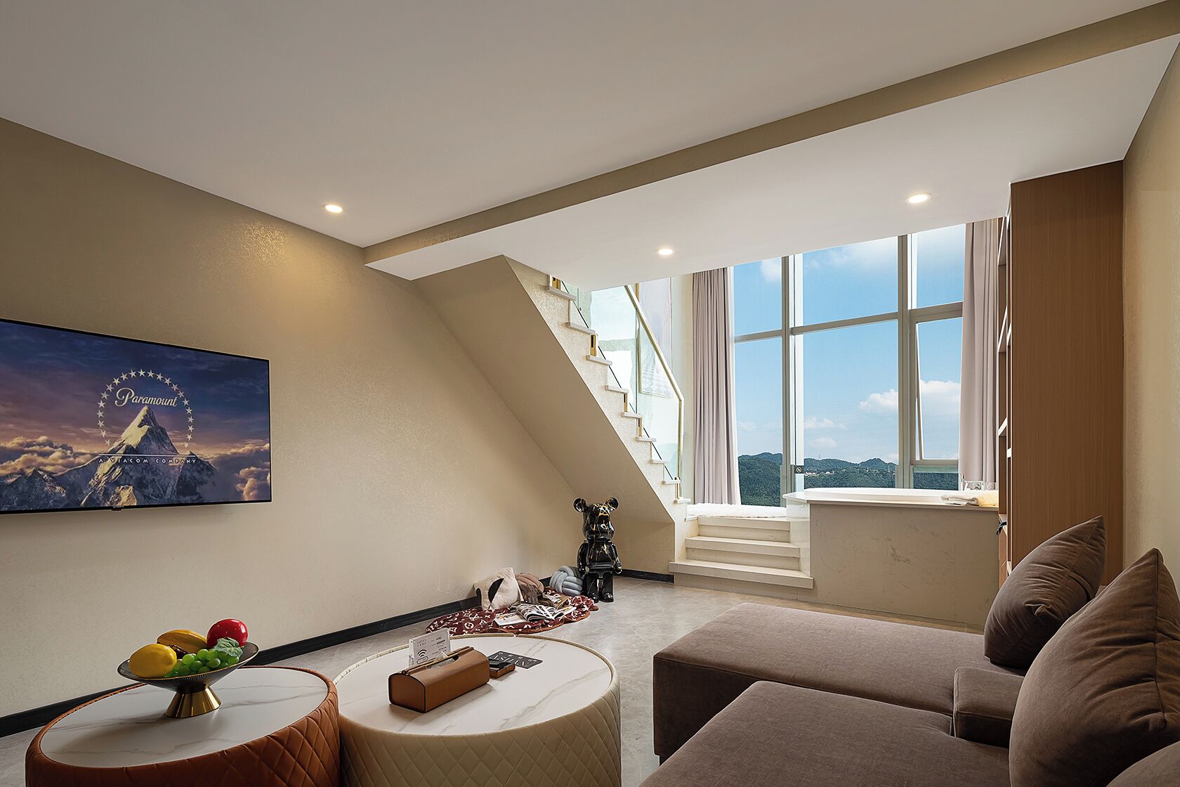 Una sala de estar moderna con un ventanal grande, una escalera y un cuadro de una montaña.