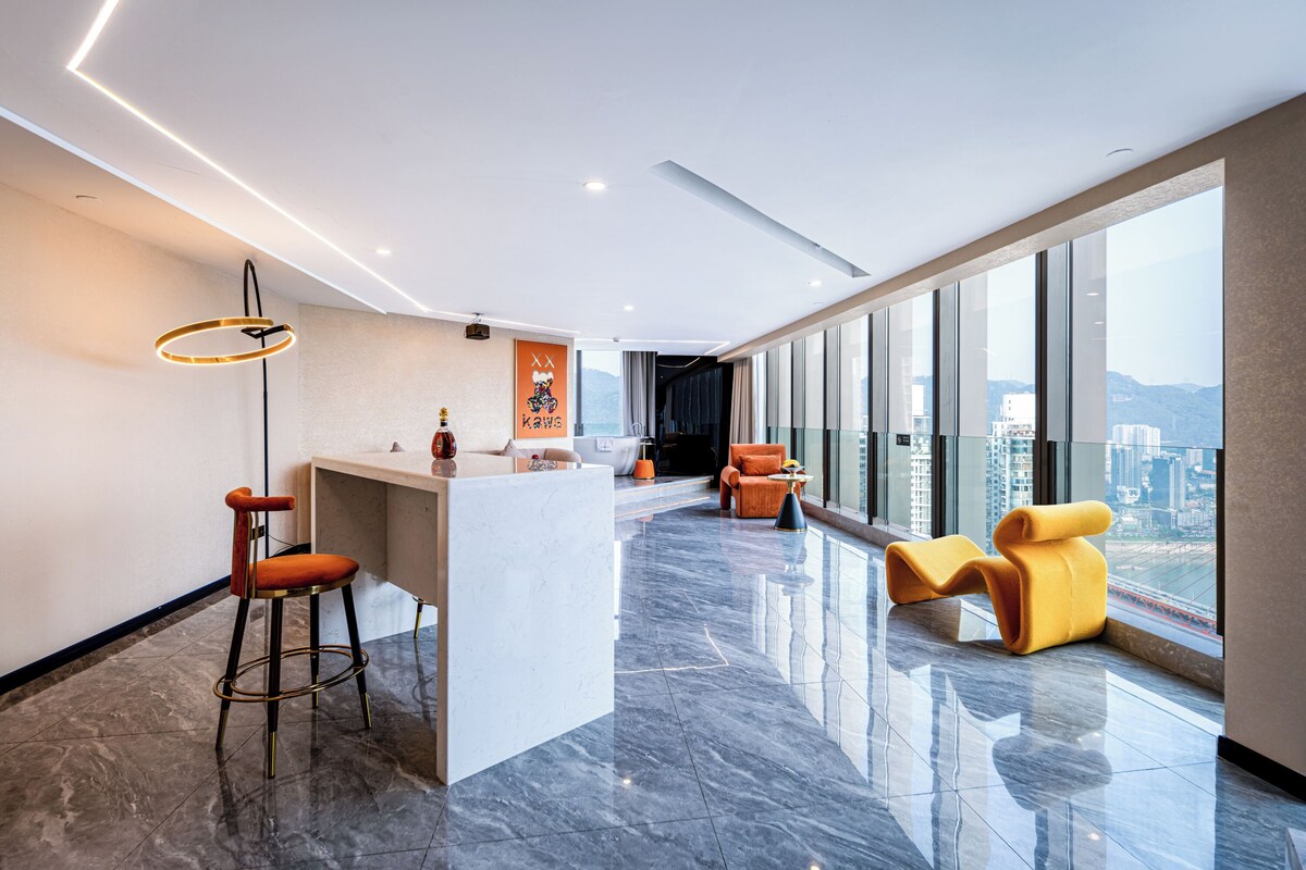 A modern hotel lobby with a bar area, seating, and large windows offering city views.