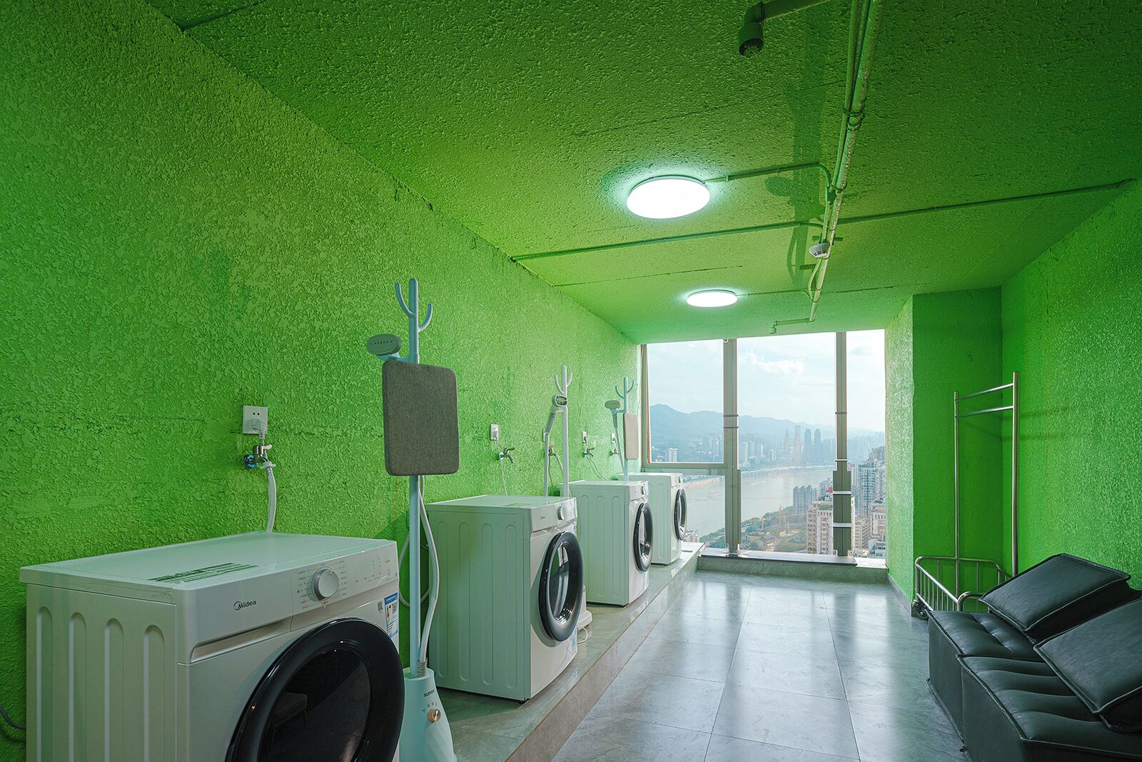 Un cuarto de lavandería con vistas a un paisaje urbano a través de amplios ventanales.