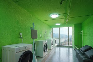 Un cuarto de lavandería con vistas a un paisaje urbano a través de amplios ventanales.