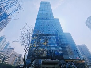 A tall, modern skyscraper with a glass facade, surrounded by other high-rise buildings. - Chongqing Ashan River View Hotel (Yuzhong District)