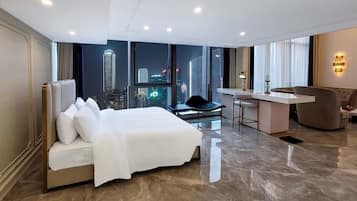 Habitación de hotel con cama, escritorio, silla y vista a un paisaje urbano.