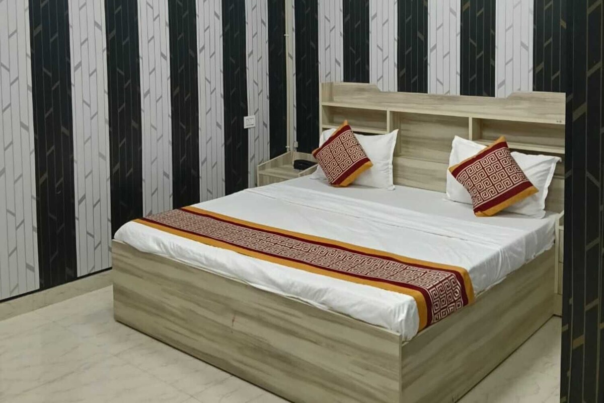 Un dormitorio con cama, ventilador de techo y papel tapiz estampado.