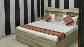 Un dormitorio con cama, ventilador de techo y papel tapiz estampado.