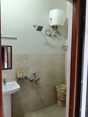 A bathroom with a sink, a shower, and a toilet. - Mansa Hotel and Lawn (Lucknow)