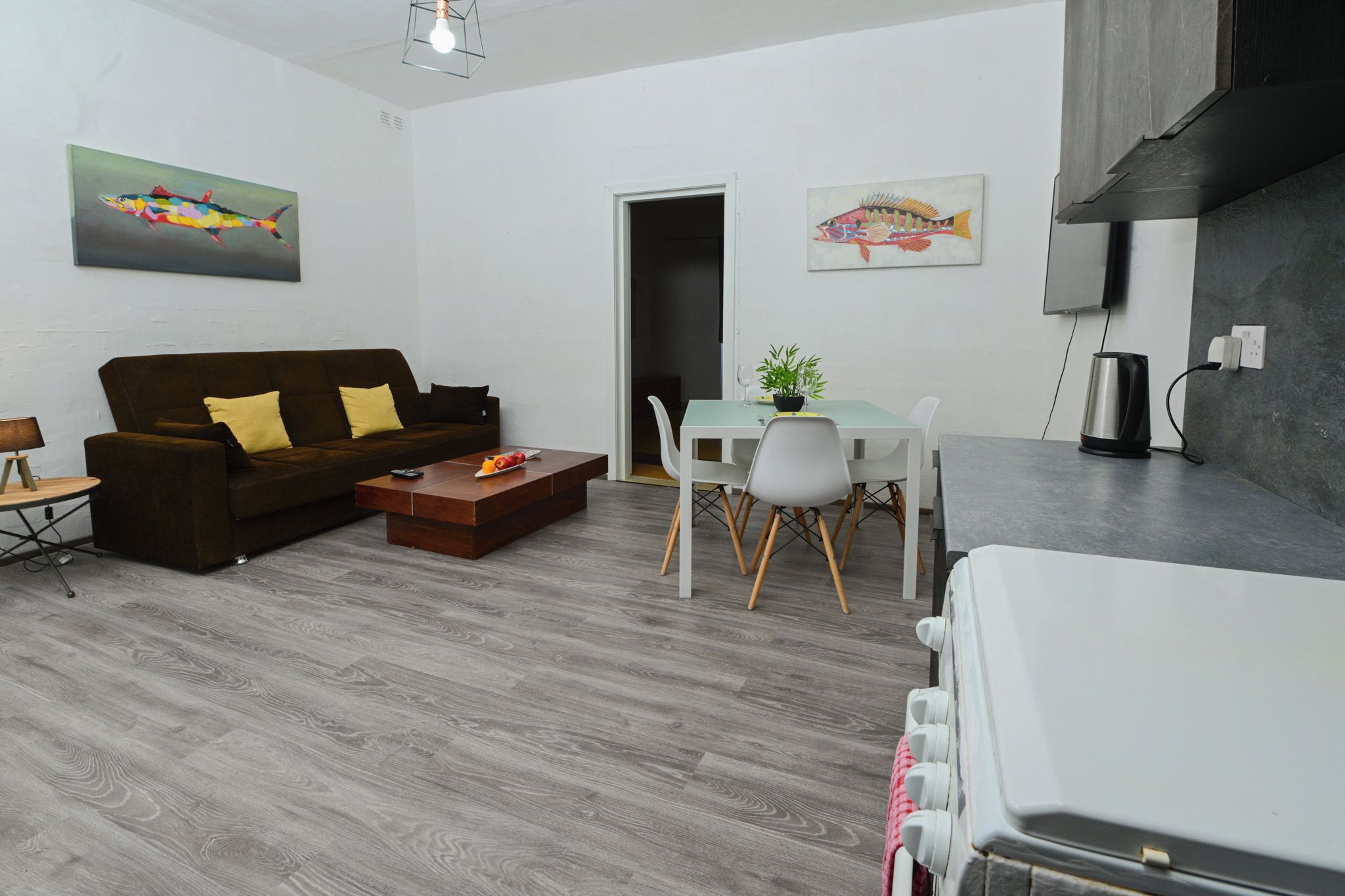 A modern living room with a sofa, coffee table, and dining area.