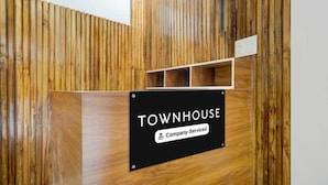Een receptiebalie met een bord waarop 'TOWNHOUSE Company-Serviced' staat.