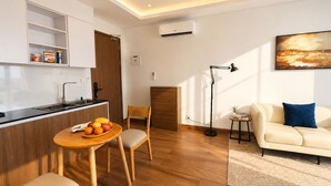 A modern living space with a kitchen, dining area, and seating. - One Studio Suite by PSH (Ou Chrov)