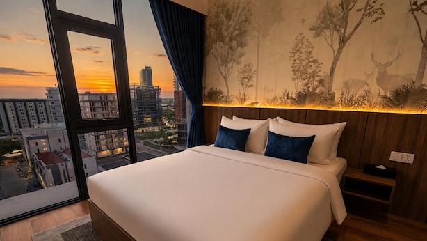 A modern hotel room with a large bed, a view of the cityscape, and a mural on the wall. - One Studio Suite by PSH (Ou Chrov)