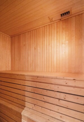 A wooden sauna with slatted walls and benches.