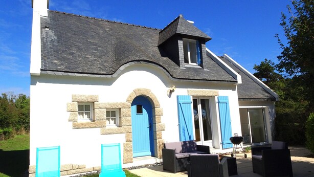 A house with a stone facade, a blue door, and a small porch area with outdoor furniture. - Lovely Holiday Home in Sarzeau for 8 (Sarzeau)