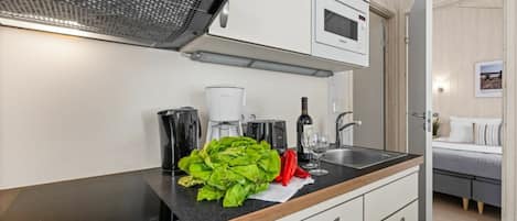 Una cocina moderna con horno empotrado, cafetera y microondas.