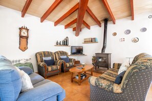 A cozy living room with a fireplace, a television, and patterned furniture. - Villa Malagarba - By Dream Villas Pollensa (Pollensa)