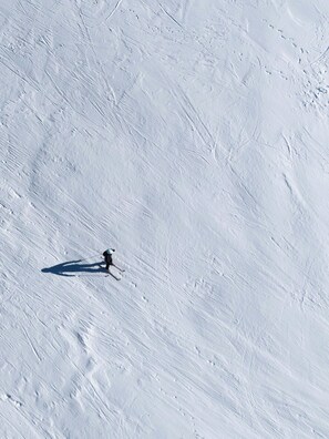 A snowy slope with a skier. - Agréable Studio accessible 3p coeur de la station (Les Orres)