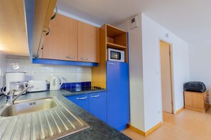 A compact kitchen with a sink, a microwave, and a stove. - Super appart confortable ! au pied des pistes (Les Orres)