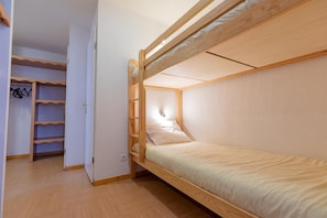 A bunk bed with a wooden frame and a single bed below. - Super appart confortable ! au pied des pistes (Les Orres)