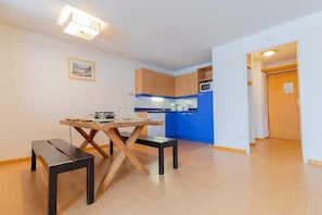 Eine moderne Küche mit Holzschränken, einem Esstisch mit Bänken und einer blauen Akzentwand.
