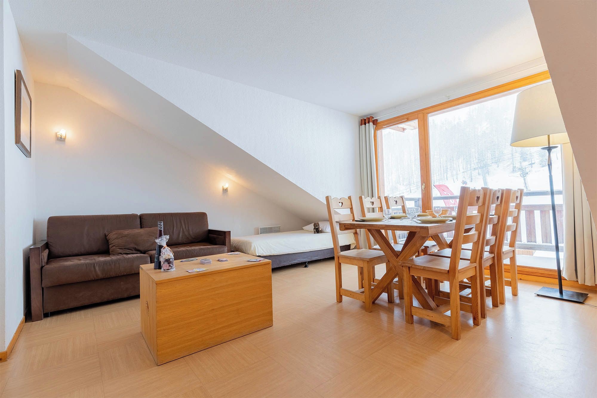 Ein modernes Wohnzimmer mit einer Couch, einem Holztisch und einem Essbereich mit Holzsesseln und einem Tisch.