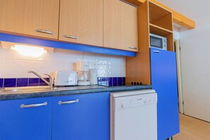 Eine Küche mit Holzausstattung, einer Mikrowelle, einem Toaster und einem Geschirrspüler.