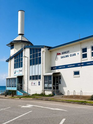 A white building with a sign for Henley Sailing Club, featuring a cafe named Beach Break Cafe. - Driftwood at West Beach - Steps to Sand & Sailing (West Beach)