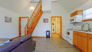 A spacious kitchen with wooden cabinets, a built-in oven, and a microwave.