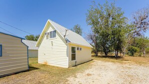 Il s’agit d’un bâtiment en bois d’un seul étage, de couleur claire, avec un toit à pignon, une petite fenêtre et une porte.