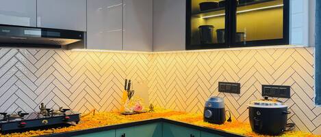 A modern kitchen with teal cabinets, a herringbone tile backsplash, and a gas stove.