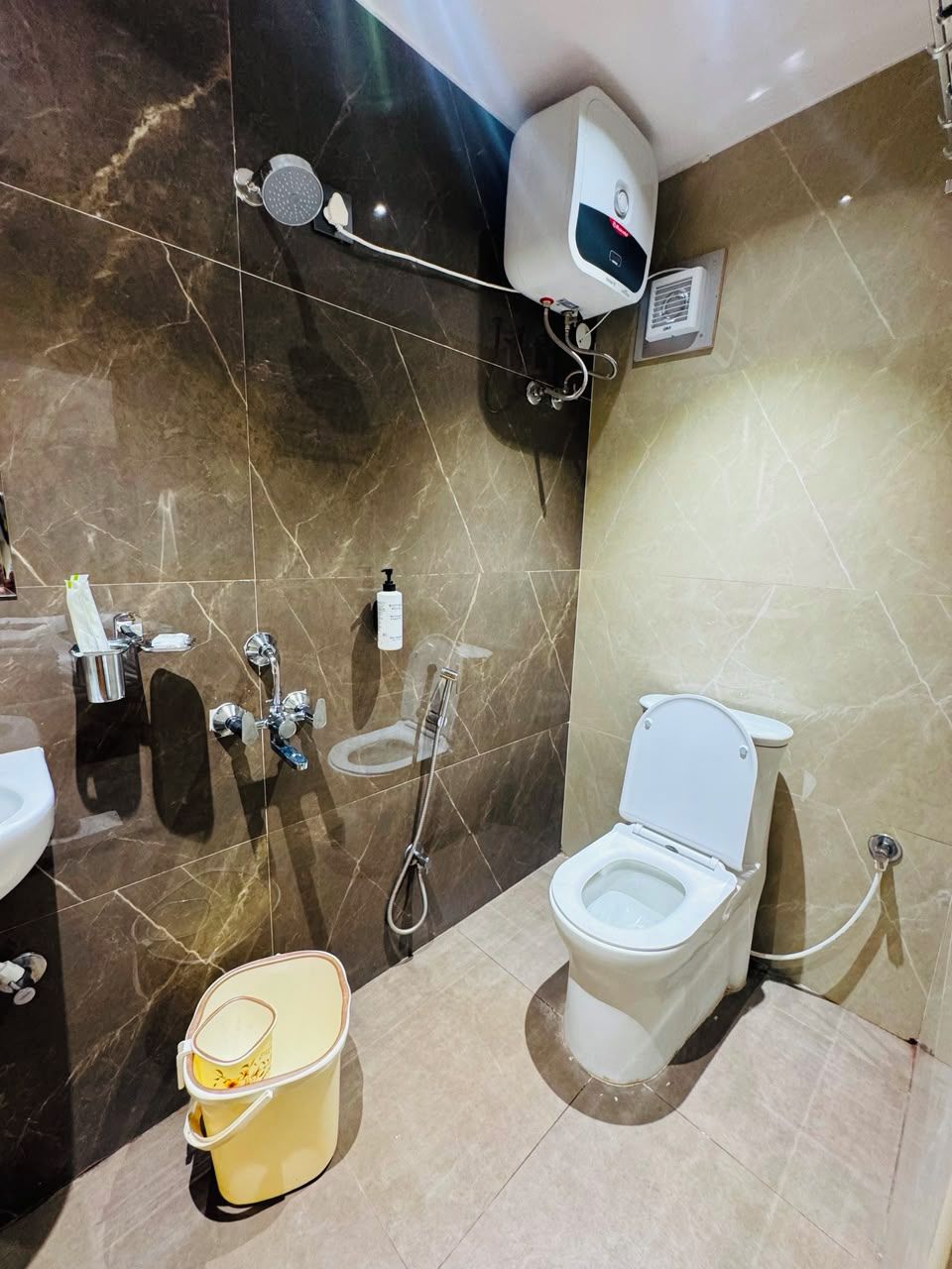 Ein Badezimmer mit Toilette, Bidet und Handtrockner.
