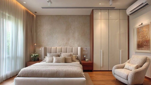 Un dormitorio con una cama grande, un armario, una silla y una mesita de noche.