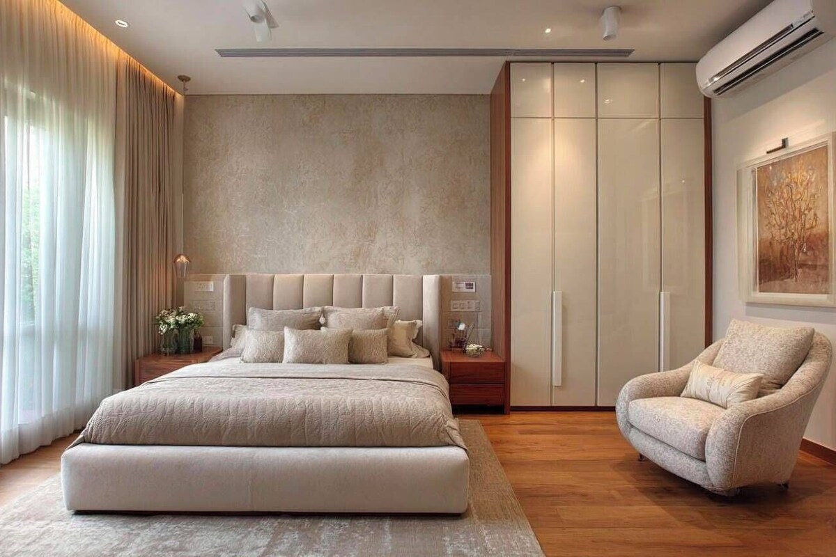 Un dormitorio con una cama grande, un armario, una silla y una mesita de noche.