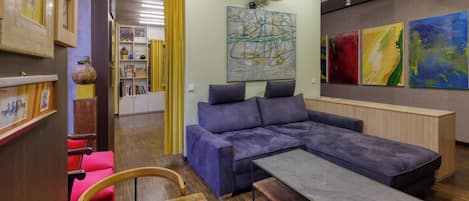 Ein modernes Wohnzimmer mit einer Eckcouch, einem Holztisch und einem roten Sessel.