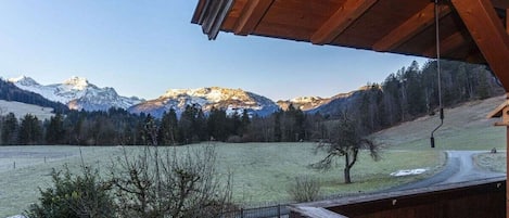 Un balcón de madera con vistas a un paisaje montañoso.