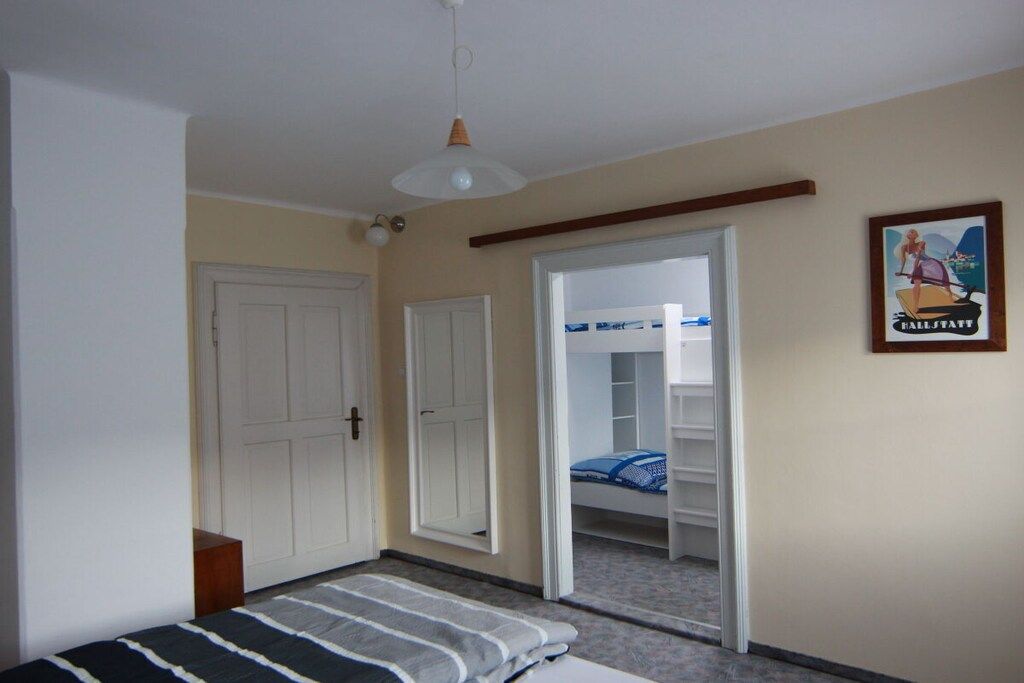 Une chambre à coucher avec un lit, une armoire, une porte et une affiche accrochée au mur.
