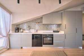 A modern kitchen with a built-in oven, dishwasher, and a large island with a sink. - Carlsen, GOAT, Unique, Full City View Terrace (Kadıköy)