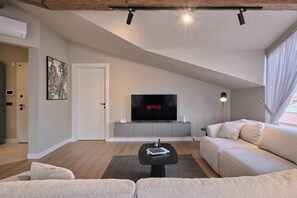 A modern living room with a flat-screen TV, a sofa, a coffee table, and a lamp. - Carlsen, GOAT, Unique, Full City View Terrace (Kadıköy)