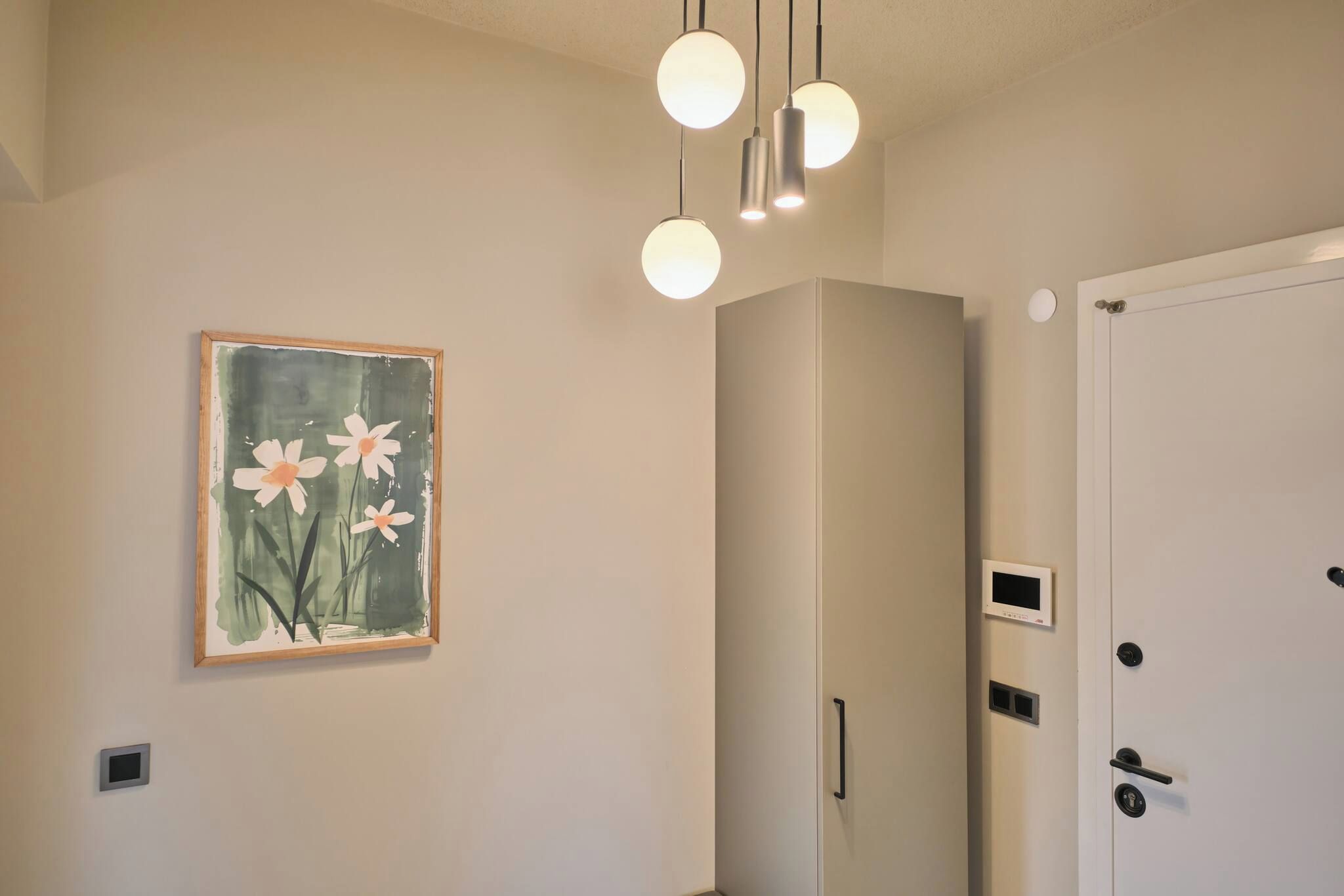 A room with a painting of flowers, a wardrobe, and a door with a handle.