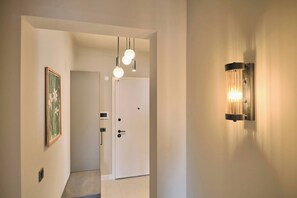 A hallway with a door, a wall-mounted light fixture, and a framed picture. - Carlsen, GOAT, Unique, Full City View Terrace (Kadıköy)